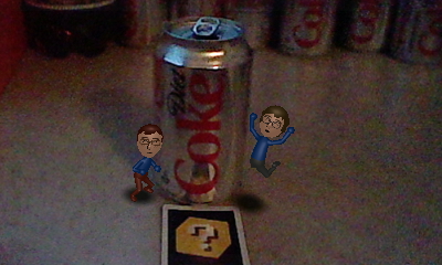 A picture of a miniature Nintendo Mii version of Tylor Lilley and Ethan Miller celebrating in front of several empty cans of Diet Coke, taken with a Nintendo 3DS and AR card
