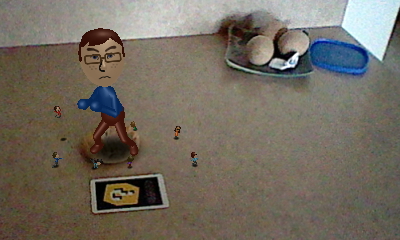 A picture of a giant Nintendo Mii version of Tylor Lilley surrounded by many smaller Nintendo Miis, taken with a Nintendo 3DS and AR card