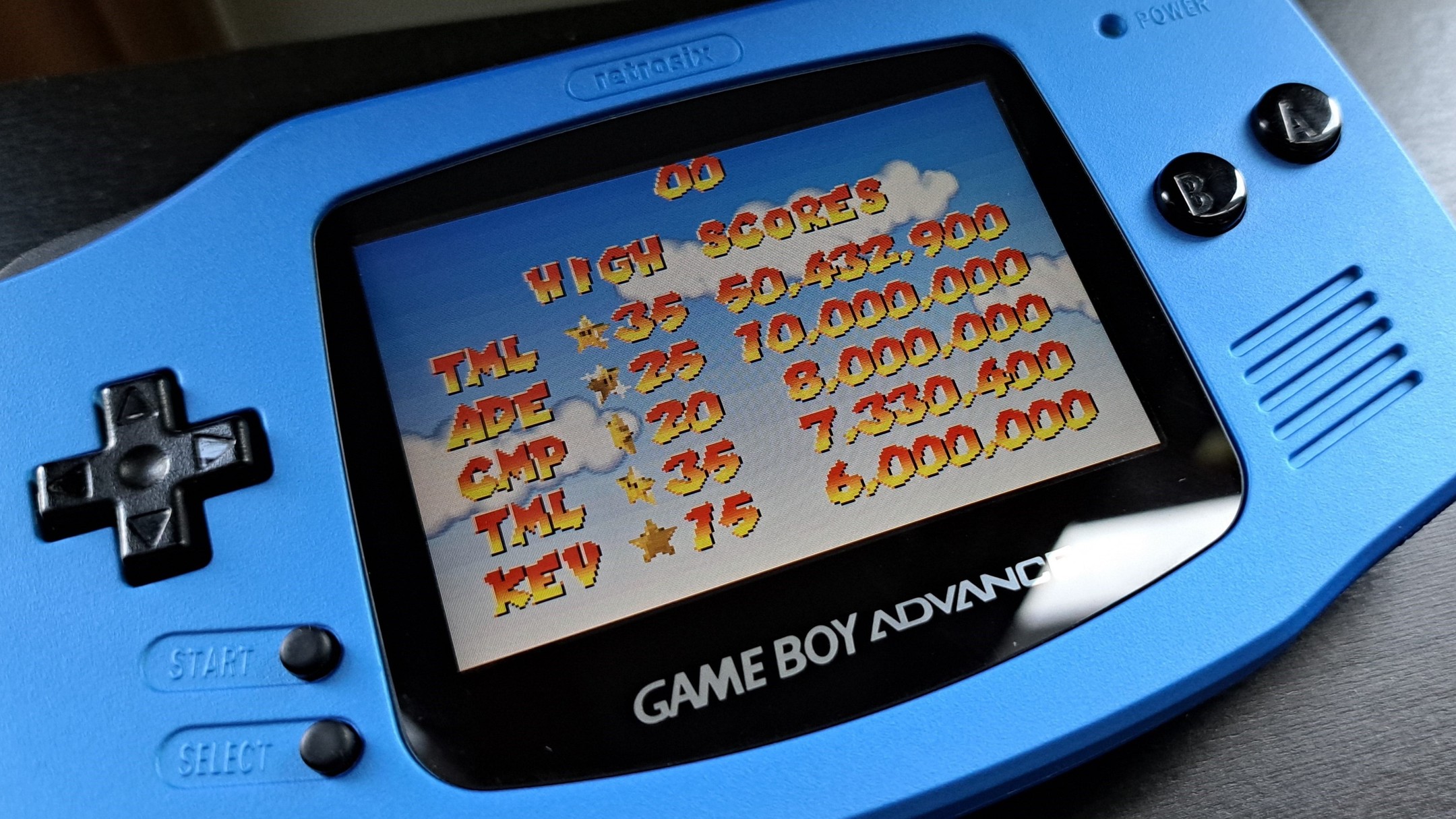 A photo of a modified Game Boy Advance displaying the high score screen for Mario Pinball Land for the Game Boy Advance showing a score of over 50 million